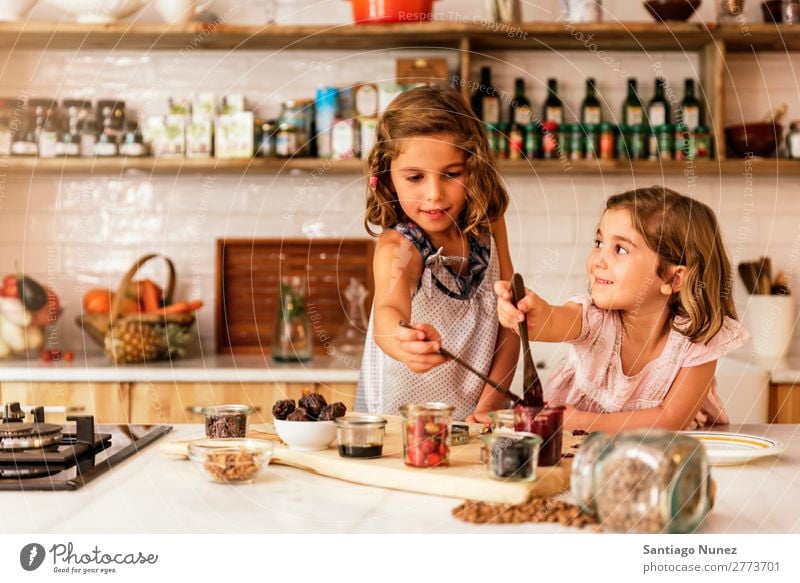 Kleine Schwestern Mädchen bereitet das Backen von Keksen vor. Kind kochen & garen Koch Küche Schokolade Speiseeis Erdbeeren Tochter Tag Glück Freude