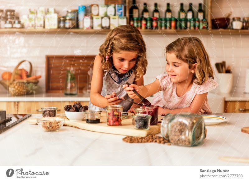 Kleine Schwestern Mädchen bereitet das Backen von Keksen vor. Kind kochen & garen Koch Küche Schokolade Speiseeis Erdbeeren Tochter Tag Glück Freude