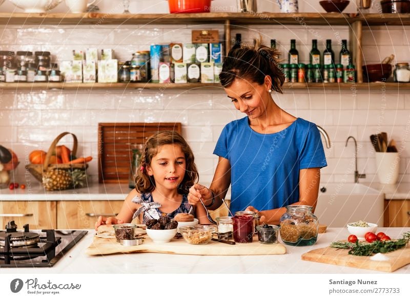 Kleines Mädchen kocht mit ihrer Mutter in der Küche. kochen & garen Koch Schokolade Speiseeis Tochter Tag Glück Freude Familie & Verwandtschaft Liebe backen