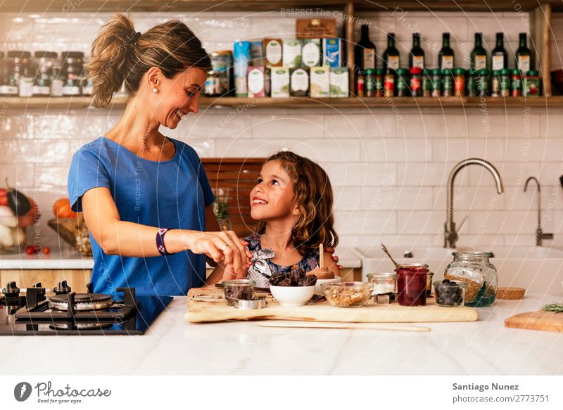 Kleines Mädchen kocht mit ihrer Mutter in der Küche. kochen & garen Koch Schokolade Speiseeis Tochter Tag Glück Freude Familie & Verwandtschaft Liebe backen