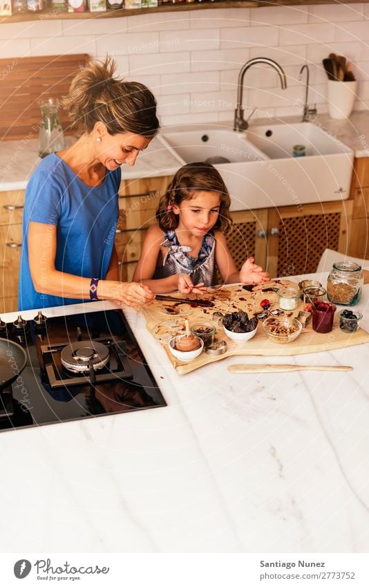 Kleines Mädchen kocht mit ihrer Mutter in der Küche. kochen & garen Koch Schokolade Speiseeis Tochter Tag Glück Freude Familie & Verwandtschaft Liebe backen