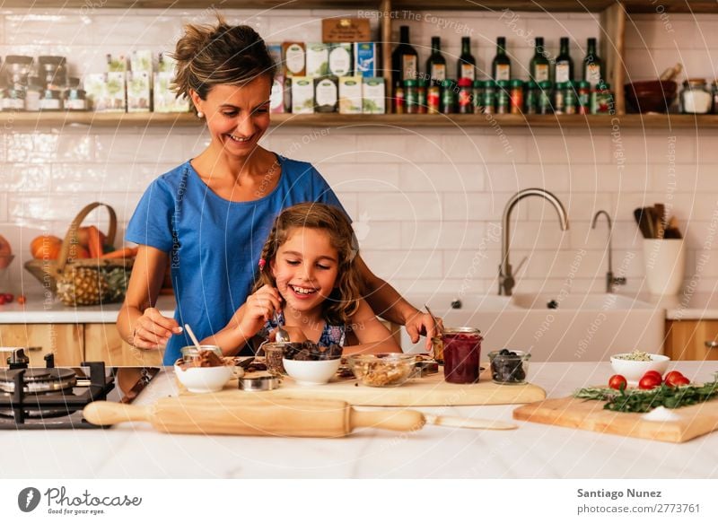 Kleines Mädchen kocht mit ihrer Mutter in der Küche. kochen & garen Koch Schokolade Speiseeis Tochter Tag Glück Freude Familie & Verwandtschaft Liebe backen