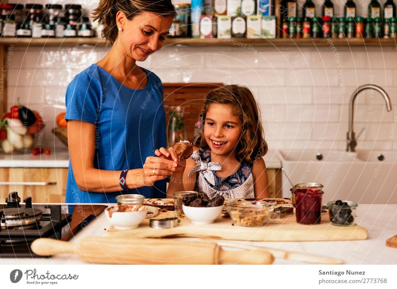 Kleines Mädchen kocht mit ihrer Mutter in der Küche. kochen & garen Koch Schokolade Speiseeis Tochter Tag Glück Freude Familie & Verwandtschaft Liebe backen