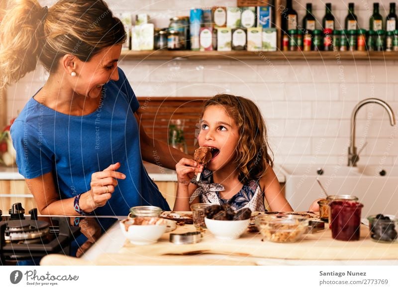 Kleines Mädchen kocht mit ihrer Mutter in der Küche. kochen & garen Koch Schokolade Speiseeis Tochter Tag Glück Freude Familie & Verwandtschaft Liebe backen