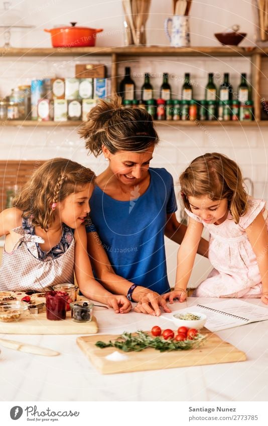 Kleine Schwestern kochen mit ihrer Mutter in der Küche. Kind Mädchen kochen & garen Koch Tomate Pizza Gemüse Tochter Aufstrich Tag Glück Freude