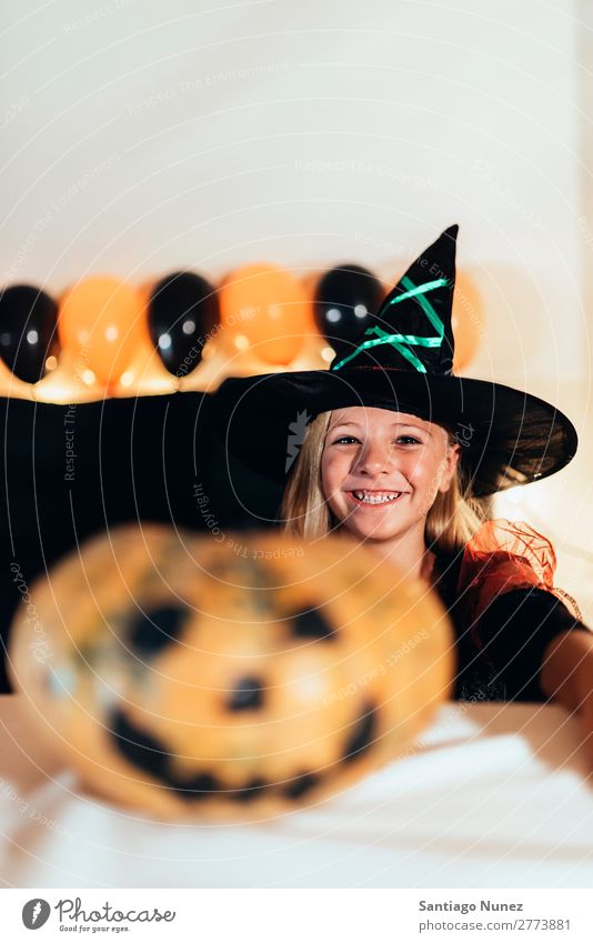 Schönes Mädchen verkleidet von einer Hexe, die zu Hause einen Kürbis schmückt. Halloween Kind malen Freude Familie & Verwandtschaft Schwester Porträt Angst