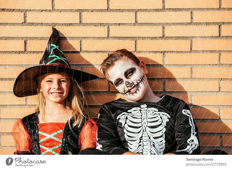 Porträt von Kindern, die auf der Straße verkleidet sind. Halloween Mädchen Junge malen Skelett Hexe Freude Familie & Verwandtschaft Schwester Freundschaft