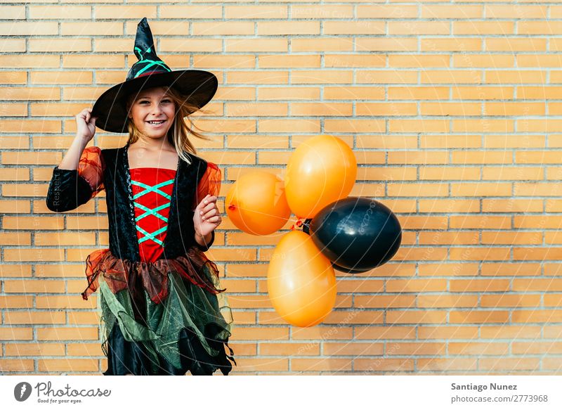 Porträt eines schönen Mädchens, das sich als Hexe auf der Straße verkleidet hat. Halloween Kind malen Freude Familie & Verwandtschaft Schwester Kürbis Angst