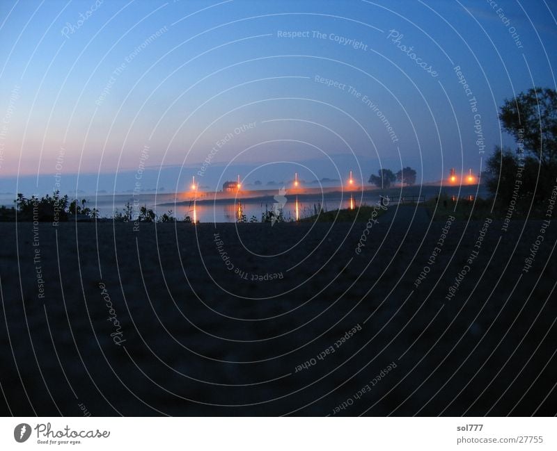 aufzeiehender Nebel und Nacht an der Elbe unheimlich Haus Langzeitbelichtung Fluss Licht