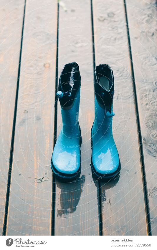 Regenstiefel, die auf einer Holzterrasse stehen, während es regnet. Freude Sommer Kind Mensch Frau Erwachsene Mann Wetter Mantel Schuhe Stiefel Gummistiefel