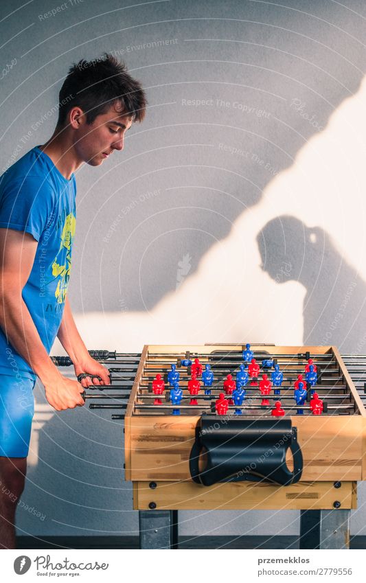 Junge Teenager Junge spielt mit einem anderen Spieler Tischfußball. Lifestyle Freude Erholung Freizeit & Hobby Spielen Sommer Sport Fußball Mann Erwachsene