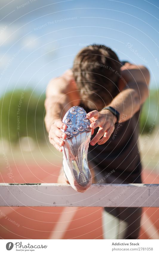 Anonymer Mann beim Aufwärmen im Stadion strecken Sportler Körperhaltung beweglich Fitness üben Athlet muskulös Gesundheitswesen Erwachsene Sprinter sportlich