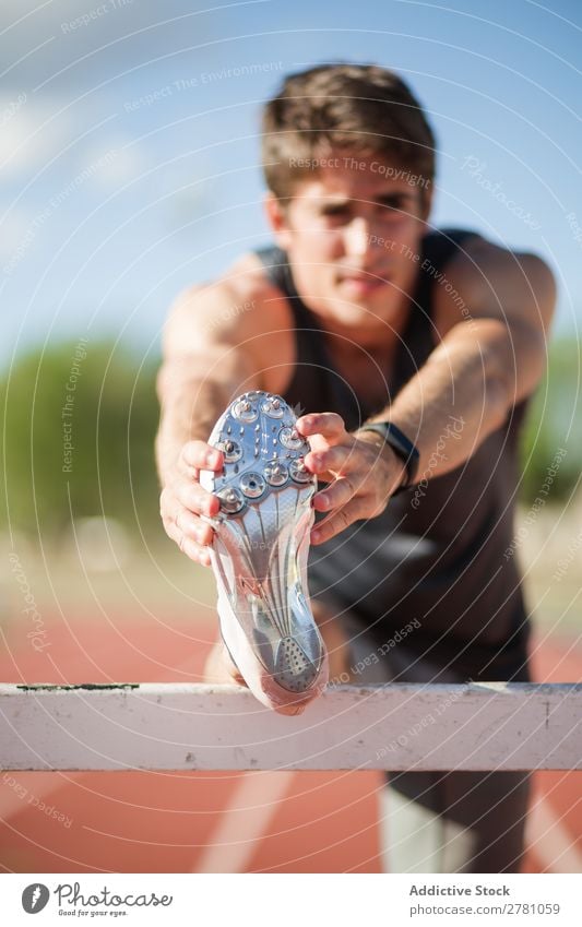 Anonymer Mann beim Aufwärmen im Stadion strecken Sportler Körperhaltung beweglich Fitness üben Athlet muskulös Gesundheitswesen Erwachsene Sprinter sportlich