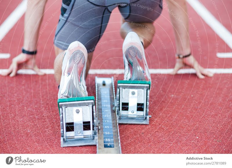 Mann verwendet Startblock zum Laufen Sportler Rennbahn Kauerstart Sprinter Sprungblock Stadion Erfolg Fitness üben Athlet muskulös Erwachsene Sportbekleidung 2