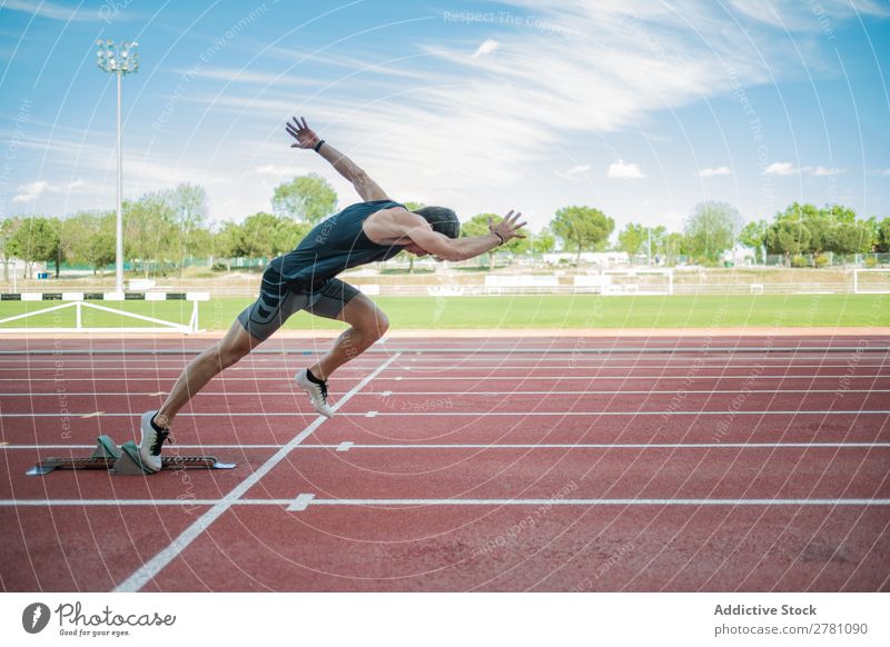 Seitenansicht des männlichen Sprinters Sportler Läufer Rennbahn Kauerstart Stadion Erfolg Fitness üben Athlet muskulös Erwachsene Sportbekleidung sportlich