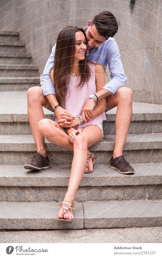 Umarmungen von glücklichen Paaren auf der Treppe Umarmen Liebe Jugendliche Frau Mann Liebespaar Mensch Glück sitzen Halt schön Lifestyle Mädchen Hand Erwachsene