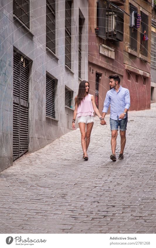 Junge Liebende, die auf der Straße spazieren gehen. Paar Glück Halt Hand laufen Frau Angesicht zu Angesicht Stil Angebot Mann Mensch Lifestyle romantisch