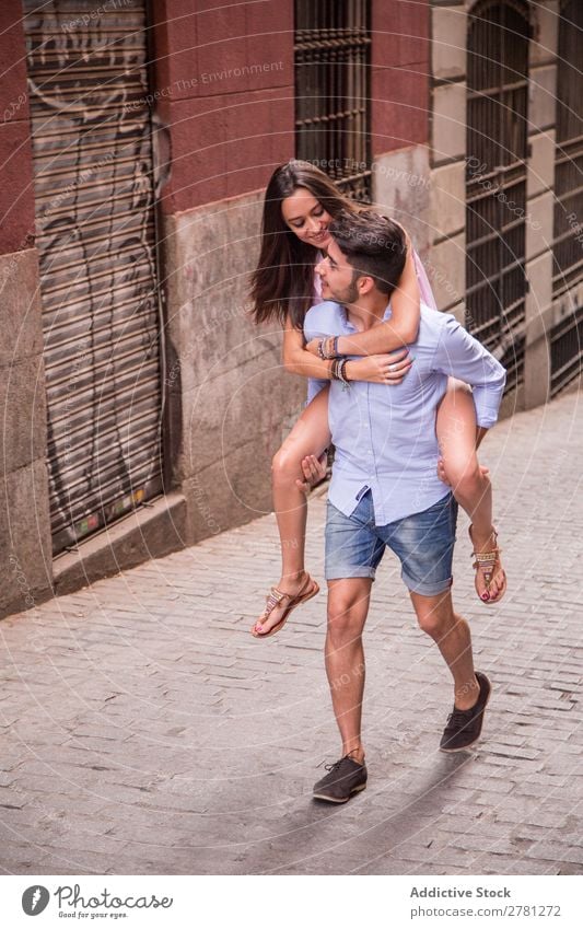 Stylischer junger Mann trägt hübsches Mädchen auf dem Rücken tragen Paar Frau Stil Freund Freundin Ausritt Halt Großstadt Mensch heiter trendy Huckepack