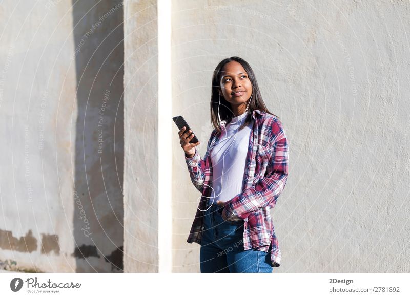 Vorderansicht einer jungen lächelnden Afroamerikanerin im Stehen Lifestyle Glück schön Entertainment Musik Telefon Mensch feminin Junge Frau Jugendliche