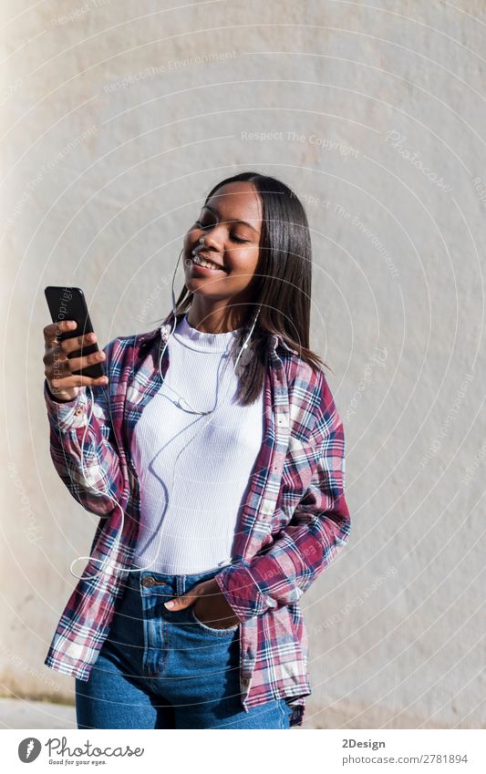 Vorderansicht einer jungen lächelnden Afroamerikanerin im Stehen Lifestyle Glück schön Entertainment Musik Telefon Mensch feminin Junge Frau Jugendliche