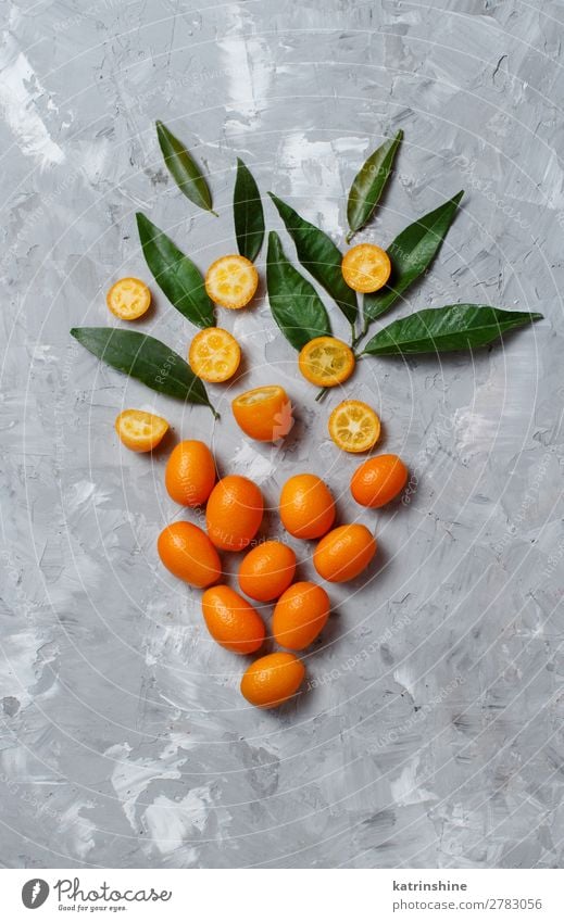 Kumquat-Früchte auf grauem Hintergrund Frucht Dessert Ernährung Vegetarische Ernährung Diät exotisch Menschengruppe Blatt frisch natürlich oben saftig gelb