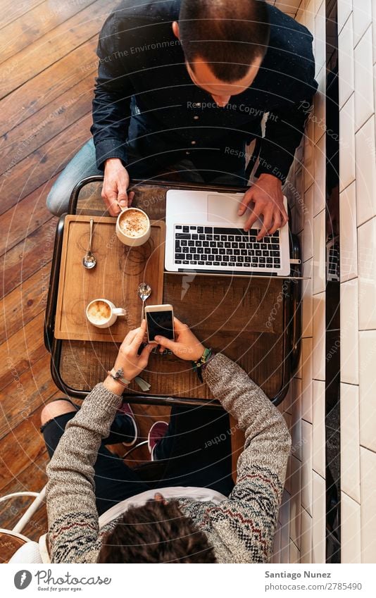 Freunde, die Handy und Laptop benutzen. Mann Kaffee Freundschaft Jugendliche Teamwork Menschengruppe Lifestyle PDA Mobile Mitteilung benutzend Text Computer