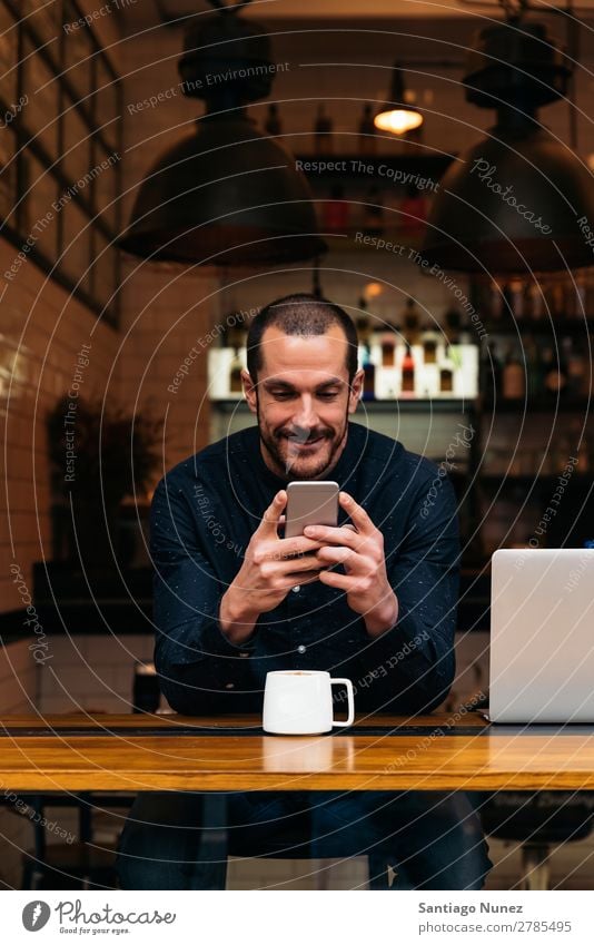 Geschäftsmann mit seinem Handy in der Cafeteria. Mann Kaffee Freundlichkeit Porträt Jugendliche Mensch Lifestyle Business Mitteilung PDA Mobile benutzend Text