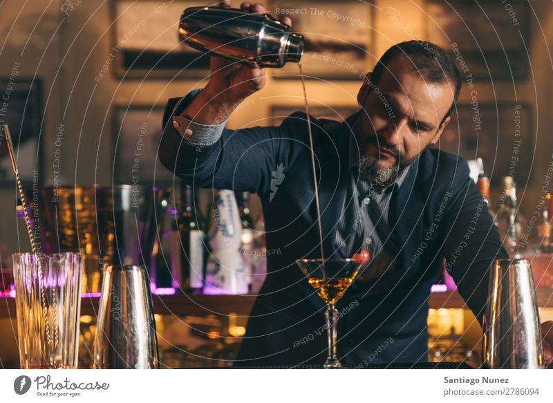 Barman macht Cocktails im Nachtclub. Schüttler Barmann Barkeeper Kellnern Mann rühren Mixologe Hinzufügen Alkohol Business Club trinken professionell Pub