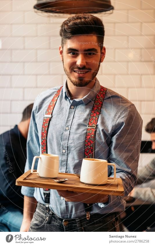 Der Kellner hält ein Tablett mit Kaffee. Kellnern Kantine Portion Café Barista kaufen Angebot Tasse schließen Aufschlag nach oben Server Jugendliche Aussicht