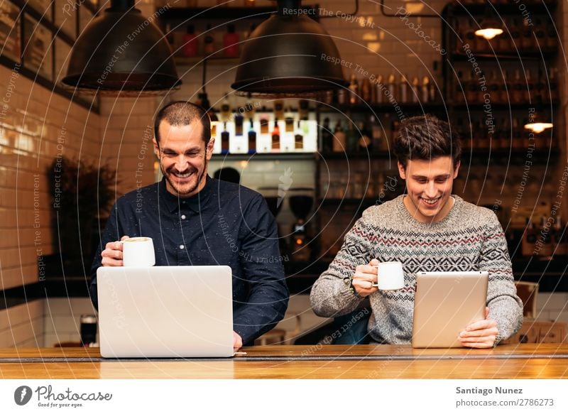 Freunde, die Handy und Laptop benutzen Mann Kaffee Freundschaft Jugendliche Teamwork Menschengruppe Lifestyle PDA Mobile Mitteilung benutzend Text Computer