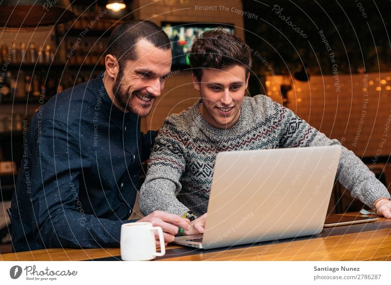 Freunde, die Handy und Laptop benutzen. Mann Kaffee Freundschaft Jugendliche Teamwork Menschengruppe Lifestyle PDA Mobile Mitteilung benutzend Text Computer