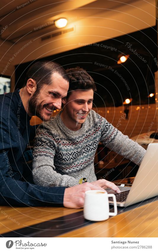 Freunde, die Handy und Laptop benutzen. Mann Kaffee Freundschaft Jugendliche Teamwork Menschengruppe Lifestyle PDA Mobile Mitteilung benutzend Text Computer