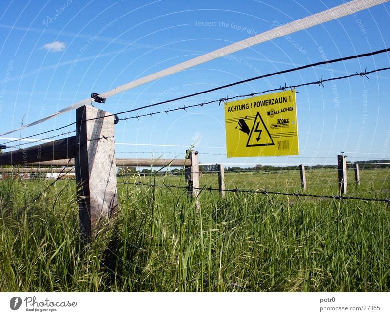 Achtung! Powerzaun! Wiese Warnschild Elektrizität grün Wolken Kondensstreifen Stacheldraht Zaun. Elektrozaun Schilder & Markierungen Warnhinweis Stromschlag