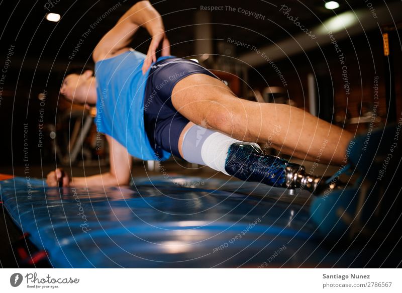 Behinderter junger Mann beim Training in der Turnhalle. Jugendliche Athlet Sport prothetisch deaktiviert hochschieben Fitness Sporthalle Aktion Beine amputieren