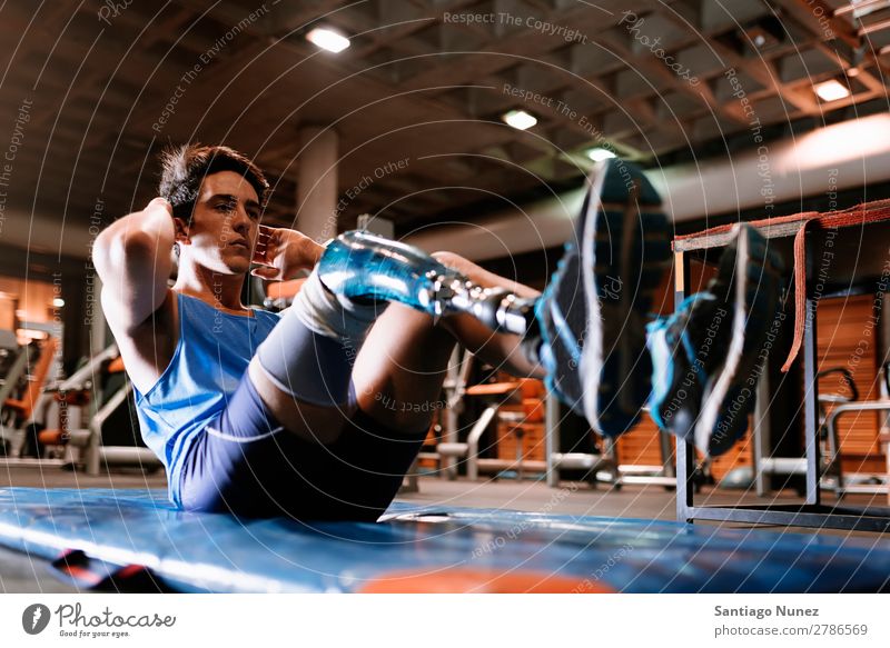 Behinderter junger Mann beim Training in der Turnhalle Jugendliche Athlet Sport prothetisch deaktiviert abdominal paralympisch Fitness Sporthalle Aktion Beine