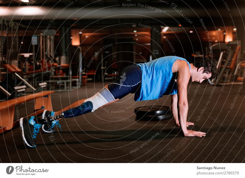 Behinderter junger Mann beim Training in der Turnhalle. Jugendliche Athlet Sport prothetisch deaktiviert hochschieben Fitness Sporthalle Aktion Beine amputieren