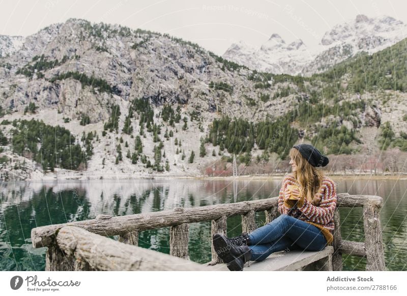 Frau auf Sitz in der Nähe des wunderschönen Sees zwischen den Hügeln im Schnee Pyrenäen wunderbar Wasser Oberfläche Berge u. Gebirge Dame Höhe Baum erstaunlich