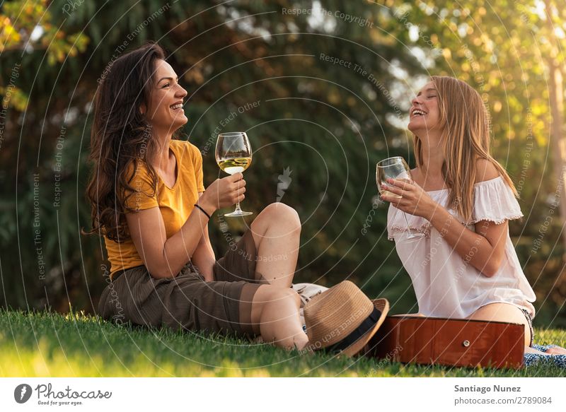 Schöne Frauen, die im Park Wein trinken. Picknick Freundschaft Jugendliche Glück Glas Gitarre Gitarrenspieler Sommer Mensch Freude Musik Erwachsene Mädchen