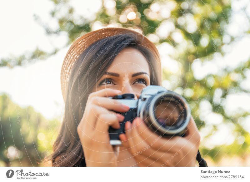 Junge Frau, die eine Kamera benutzt, um ein Foto zu machen. Fotograf Fotografie Fotokamera Jugendliche Mädchen digital weiß Freizeit & Hobby 1 nehmen analog