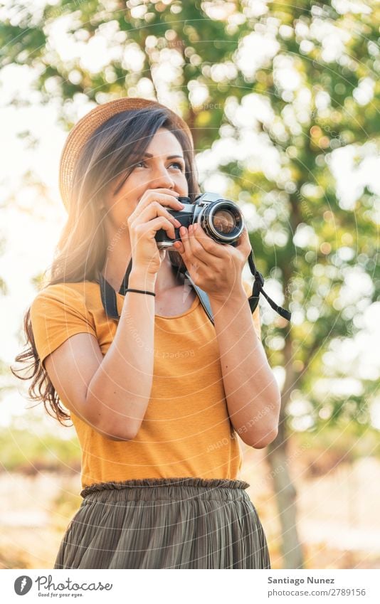 Junge Frau, die eine Kamera benutzt, um ein Foto zu machen. Fotograf Fotografie Fotokamera Jugendliche Mädchen digital weiß Freizeit & Hobby 1 nehmen analog