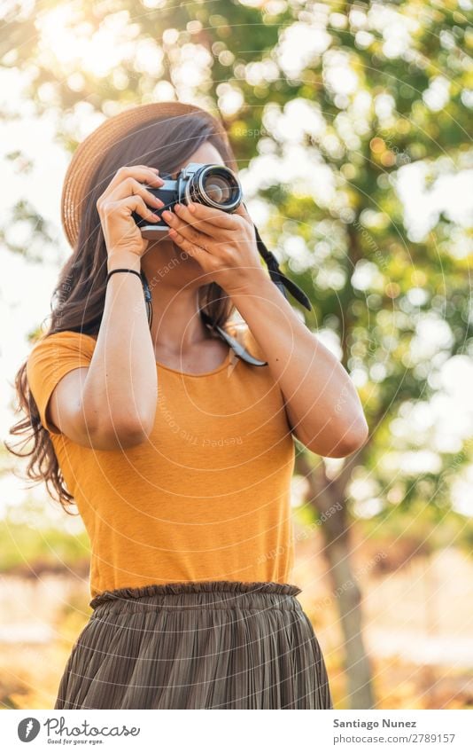 Junge Frau, die eine Kamera benutzt, um ein Foto zu machen. Fotograf Fotografie Fotokamera Jugendliche Mädchen digital weiß Freizeit & Hobby 1 nehmen analog