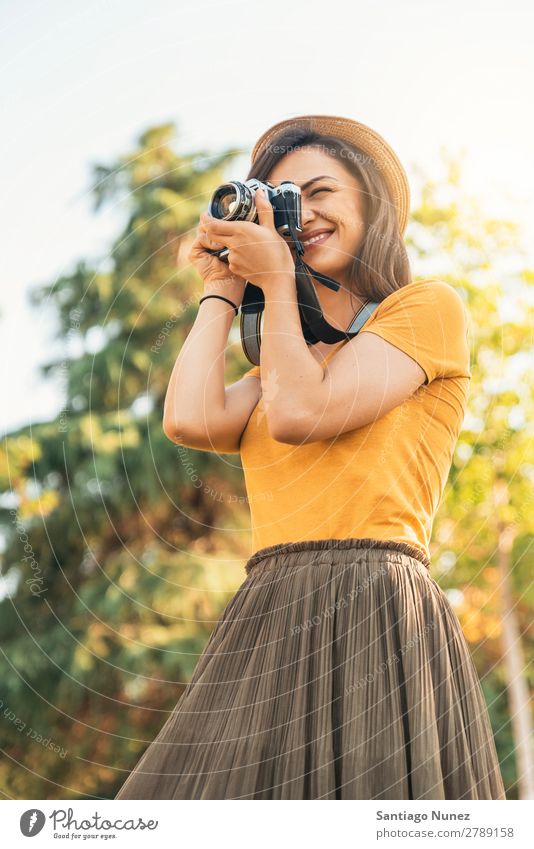 Junge Frau, die eine Kamera benutzt, um ein Foto zu machen. Fotograf Fotografie Fotokamera Jugendliche Mädchen digital weiß Freizeit & Hobby 1 nehmen analog