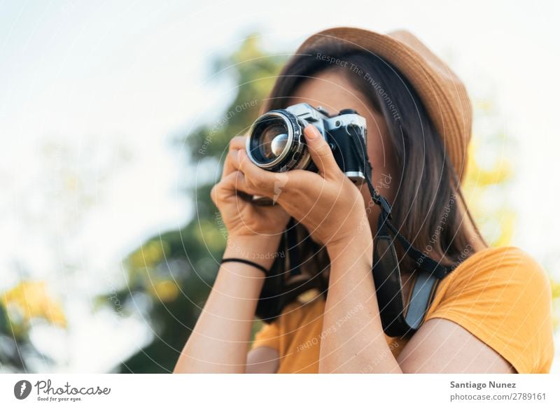 Junge Frau, die eine Kamera benutzt, um ein Foto zu machen. Fotograf Fotografie Fotokamera Jugendliche Mädchen digital weiß Freizeit & Hobby 1 nehmen analog