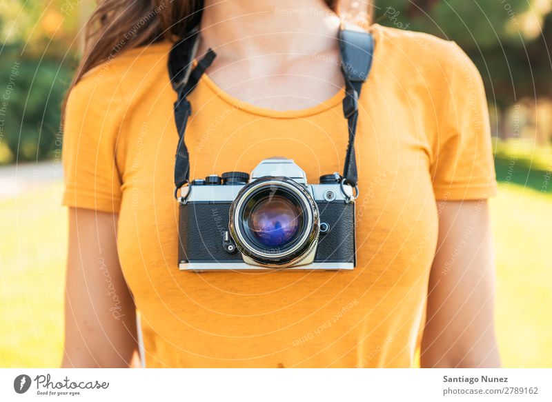 Nahaufnahme eines Fotografen mit seiner Kamera. Fotokamera professionell Fotografie analog Tasche lässig Freizeitkleidung reflektorisch kaukasische Ethnizität