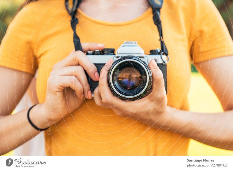 Nahaufnahme eines Fotografen mit seiner Kamera. Fotokamera professionell Fotografie analog Tasche lässig Freizeitkleidung reflektorisch kaukasische Ethnizität