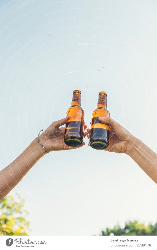 Weibliche Freunde jubeln über klirrende Flaschen Bier. Paar Toastbrot heiter Zuprosten Glas Hand Frau Glück Hintergrundbild Feste & Feiern Fröhlichkeit neu Tag