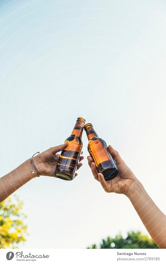 Weibliche Freunde jubeln über klirrende Flaschen Bier. Paar Toastbrot heiter Zuprosten Glas Hand Frau Glück Hintergrundbild Feste & Feiern Fröhlichkeit neu Tag