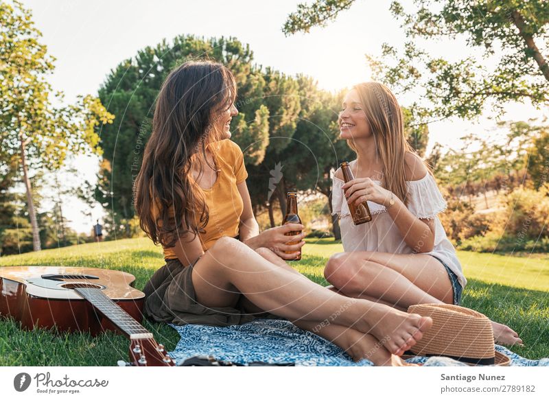 Schöne Frauen, die im Park Wein trinken. Picknick Freundschaft Jugendliche Glück Glas Zuprosten klirrend Gitarre Sommer Mensch Freude Mädchen hübsch Liebe schön