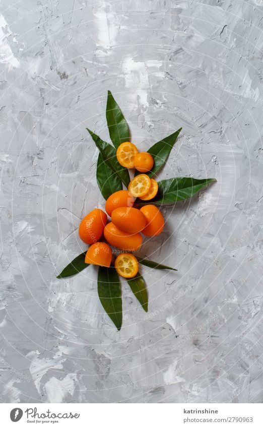 Kumquat-Früchte auf grauem Hintergrund Frucht Dessert Ernährung Vegetarische Ernährung Diät exotisch Menschengruppe Blatt frisch natürlich oben saftig gelb