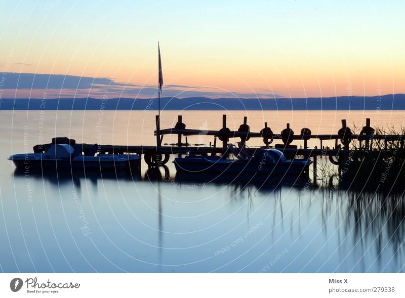 Abend Natur Landschaft Wolkenloser Himmel Küste Seeufer Meer leuchten rosa rot Steg Anlegestelle Wasserfahrzeug Tretboot Farbfoto mehrfarbig Außenaufnahme